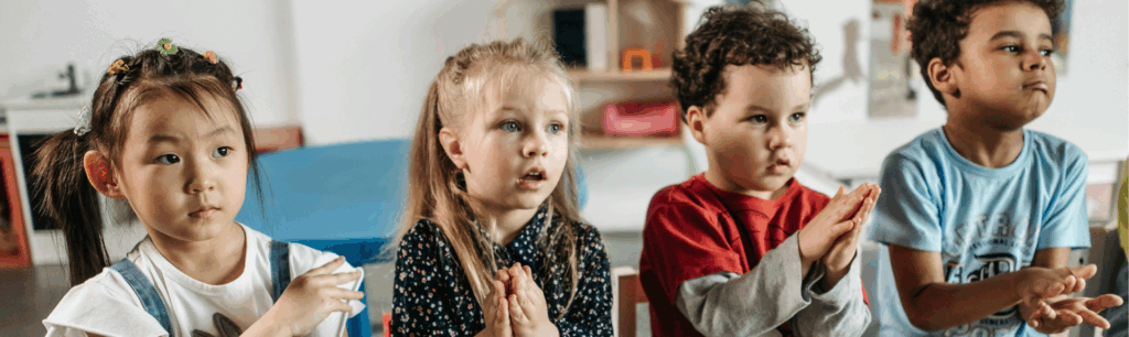 Pedagogisch medewerker staat voor de klas voor vier kinderen